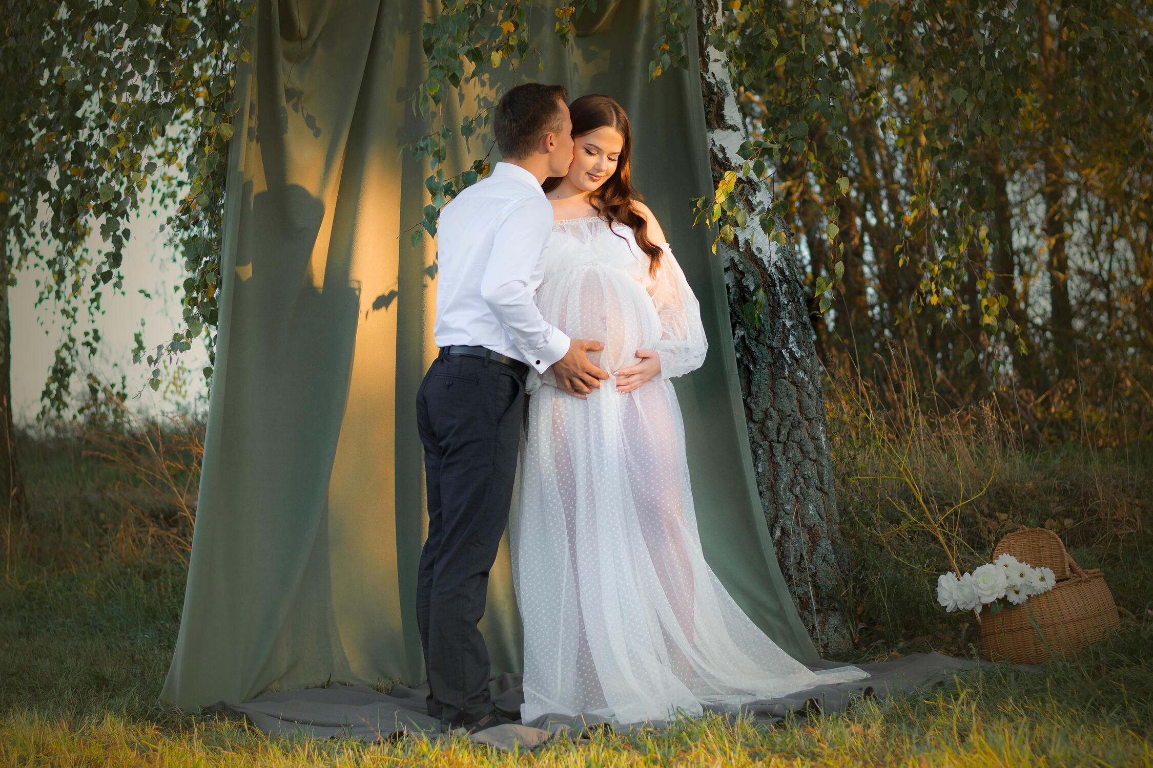 Fotosesija gamtoje, vyras bučiuoja moteriai į skruostą