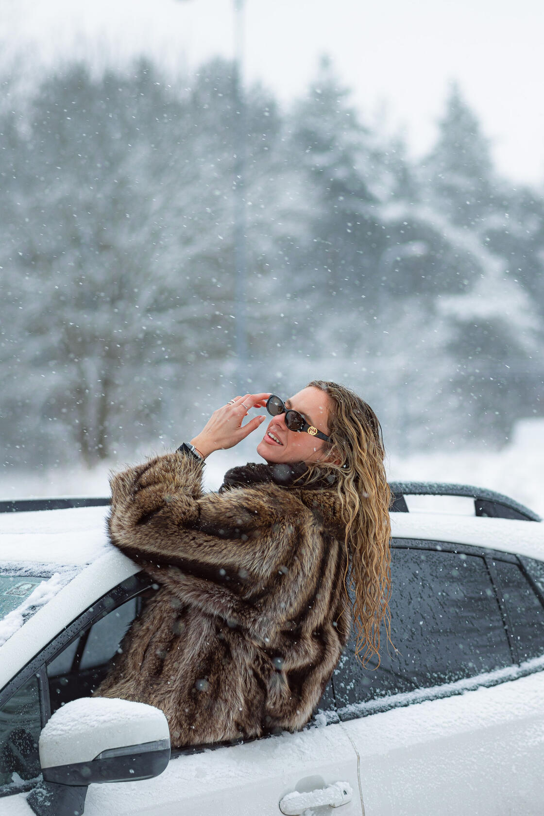 Asmeninė fotosesija, krenta sniegas, mergina pozuoja išlindusi pro automobilio langą