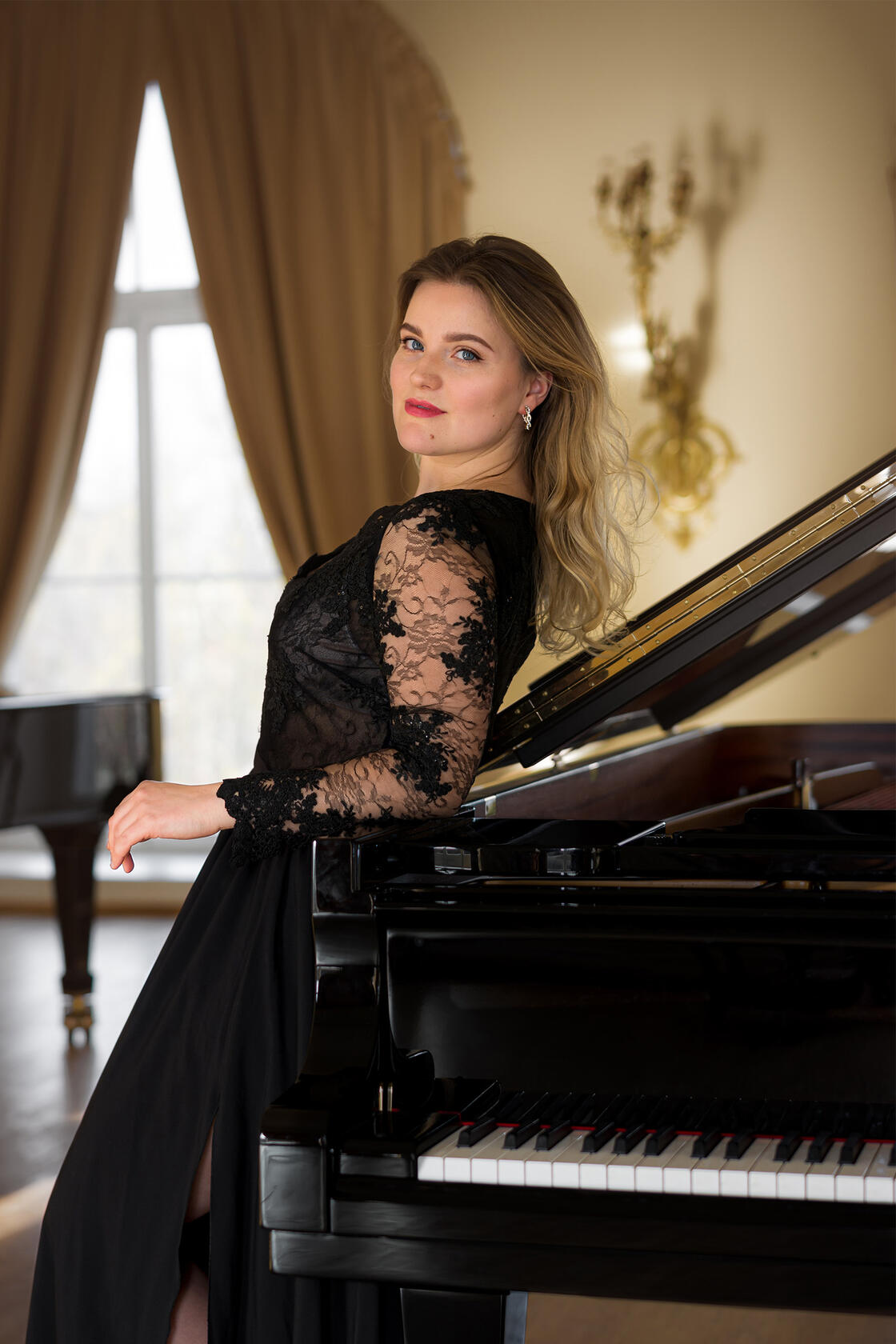 Šviesiaplaukė mergina pasirėmusi į pianiną - profesinė fotosesija koncertų afišoms - portretas