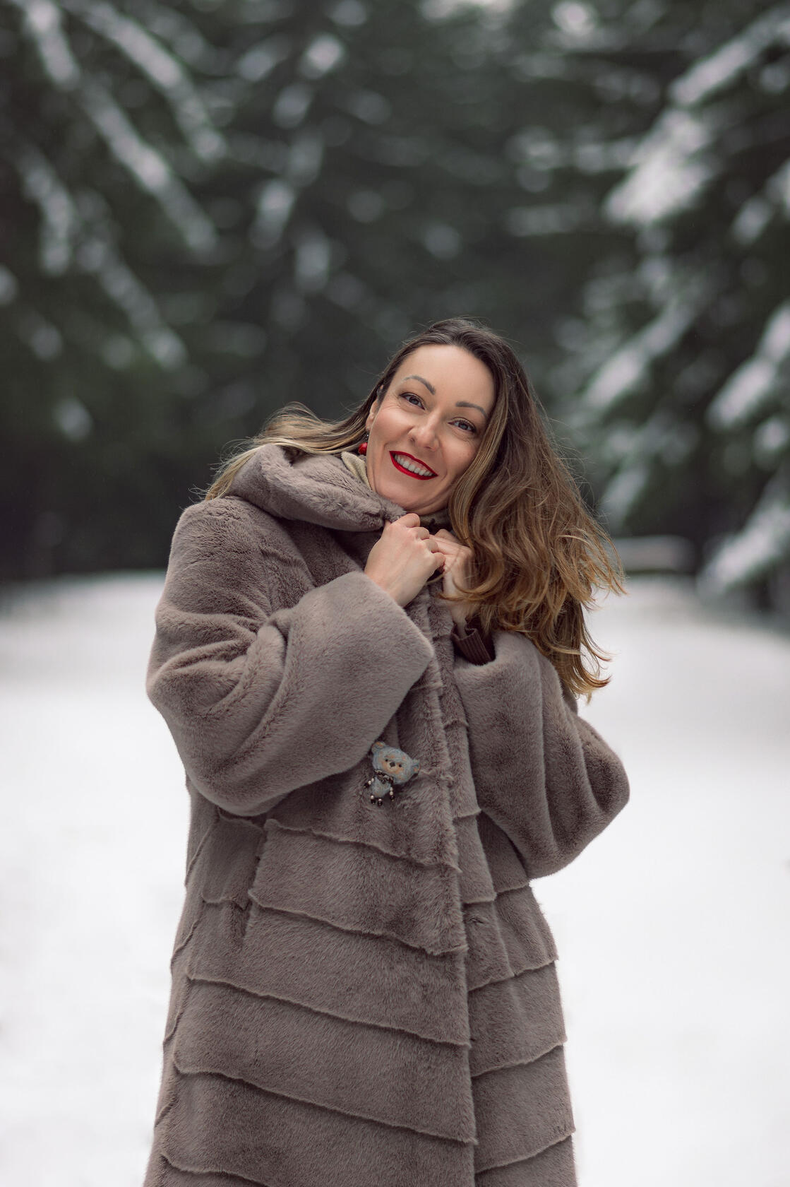 Moteris raudonomis lūpomis apsivilkusi kailiniuotą paltą, portretas