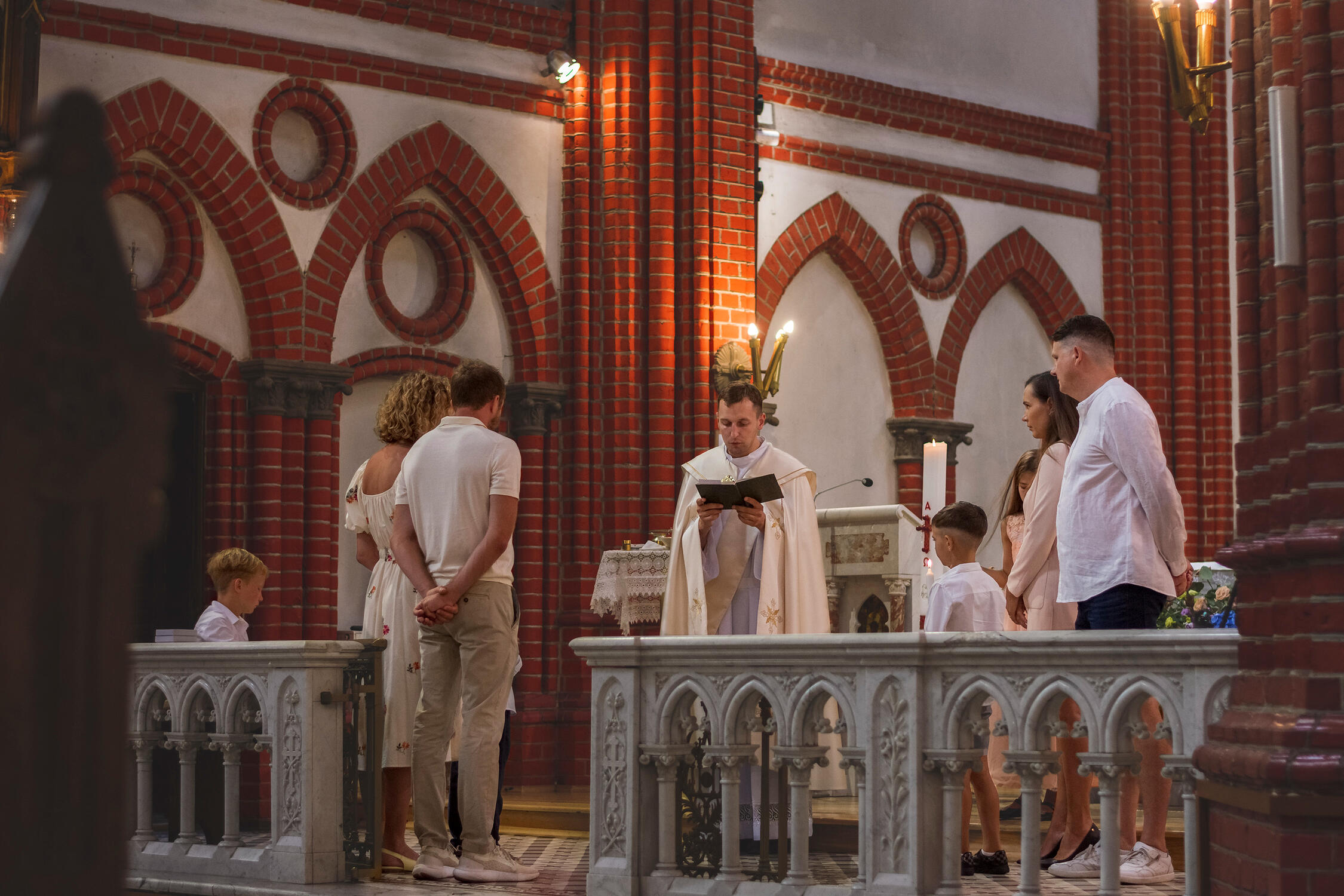 Krikštynų ceremonija iš šono, bažnyčios atmosfera