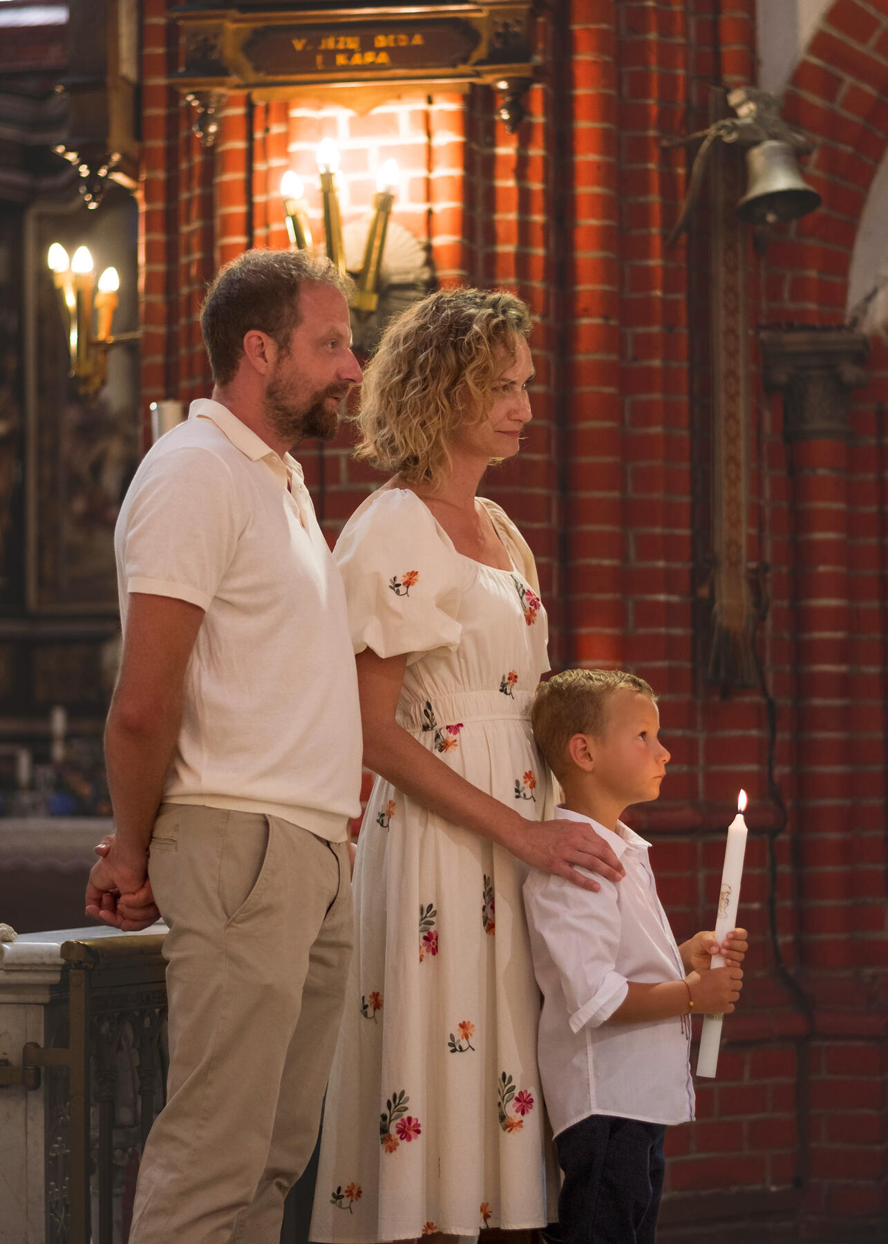 Krikštynų ceremonija, vaikas laiko degančią žvakę