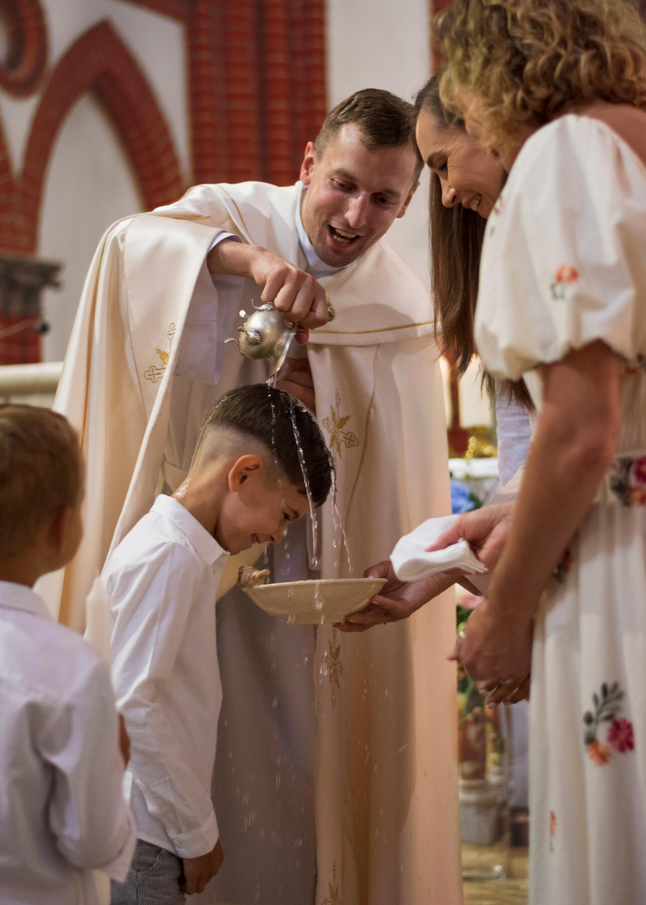 Untitled Vaikas krikštinamas, ant galvos krenta šventintas vanduo