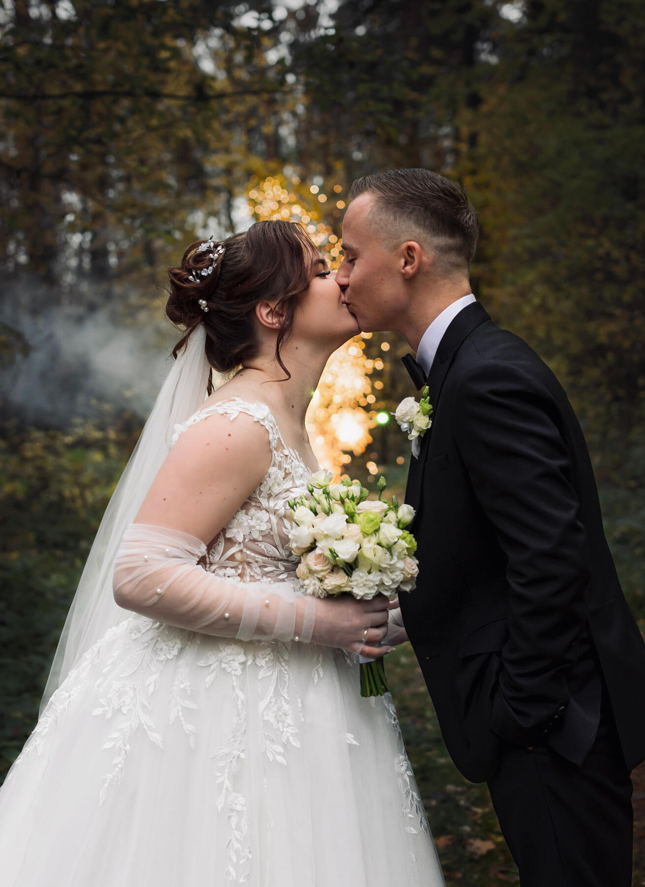 Stambaus plano fotografija, jaunųjų fotografija miške priešais fejerverką, jaunųjų bučinys