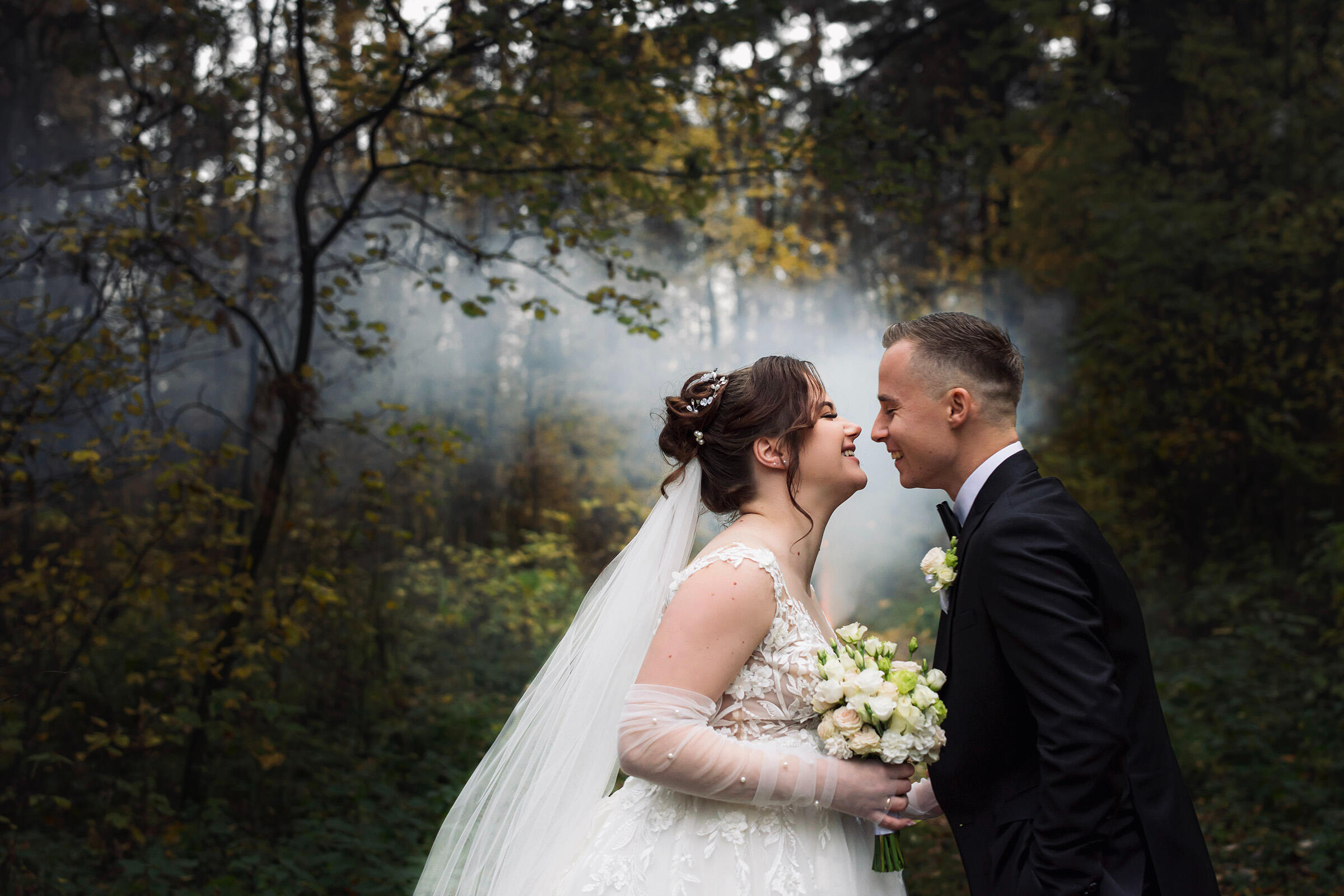 Stambaus plano fotografija, jaunųjų fotografija miške fejerverkas užgeso, laimingi jaunieji juokiasi