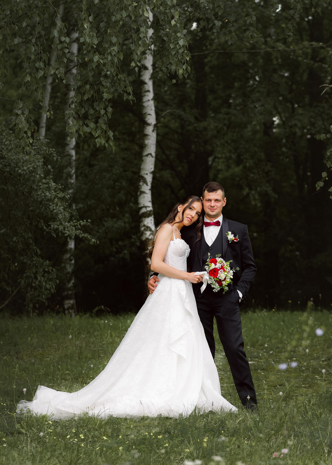Vestuvinė fotosesija Jaunoji ir jaunikis, jaunoji parėmusi galvą vyrui ant peties, fone gamtos vaizdai