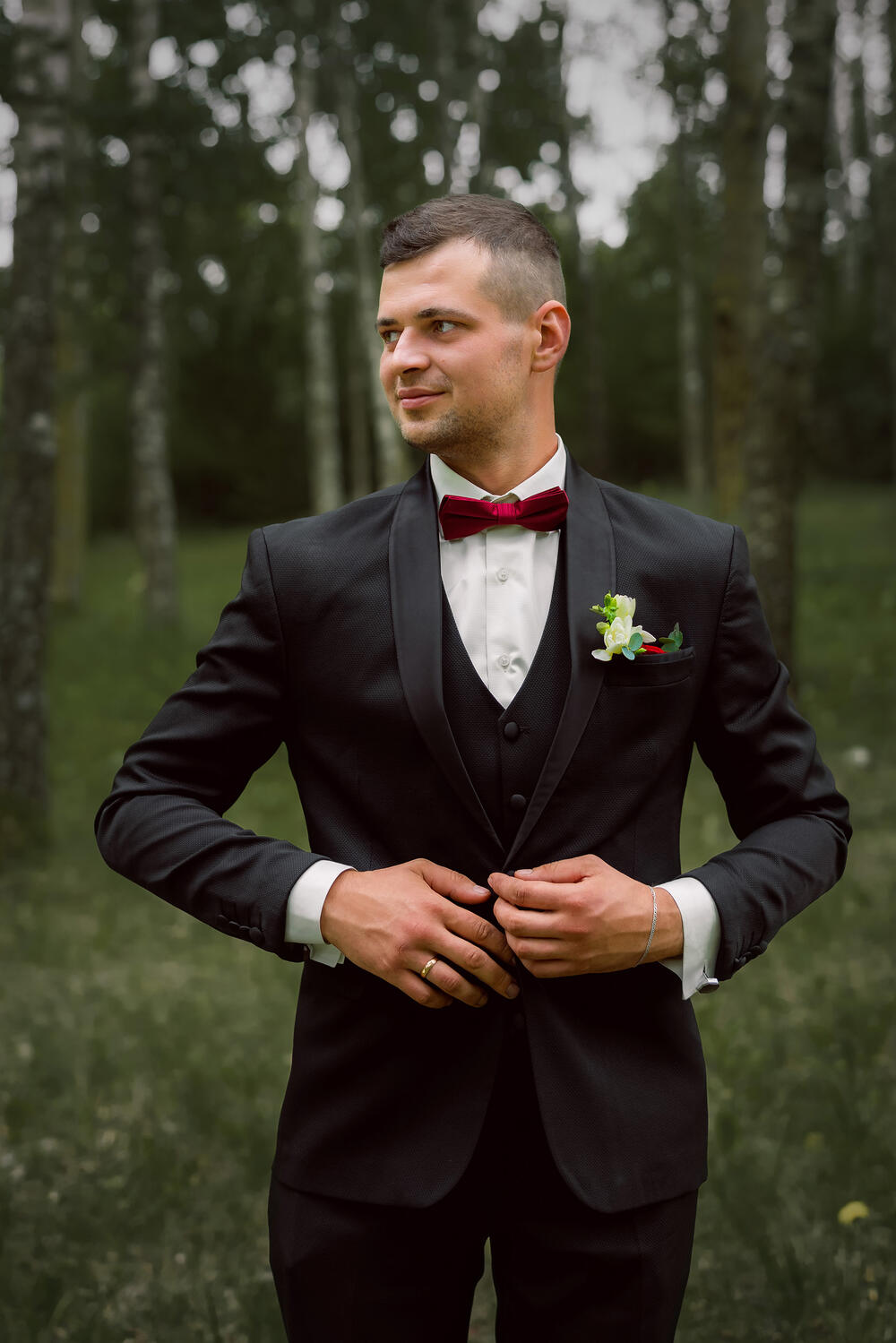 Vestuvinė fotosesija, jaunikis Jaunikis žvelgia į šalį, taisosi kostiumą. Jaunikio portretas