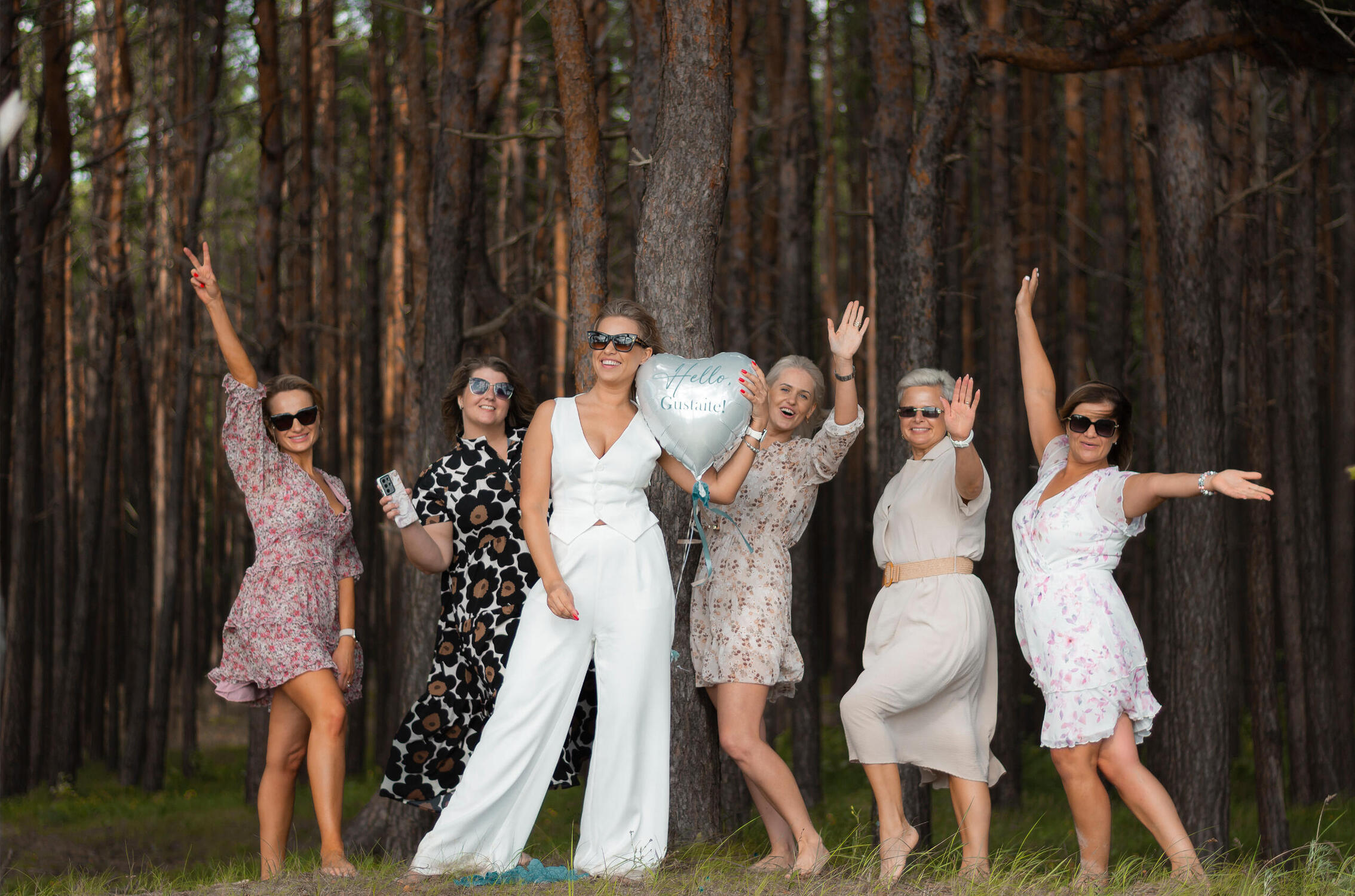 Laimingos moterys pozuoja fotografui