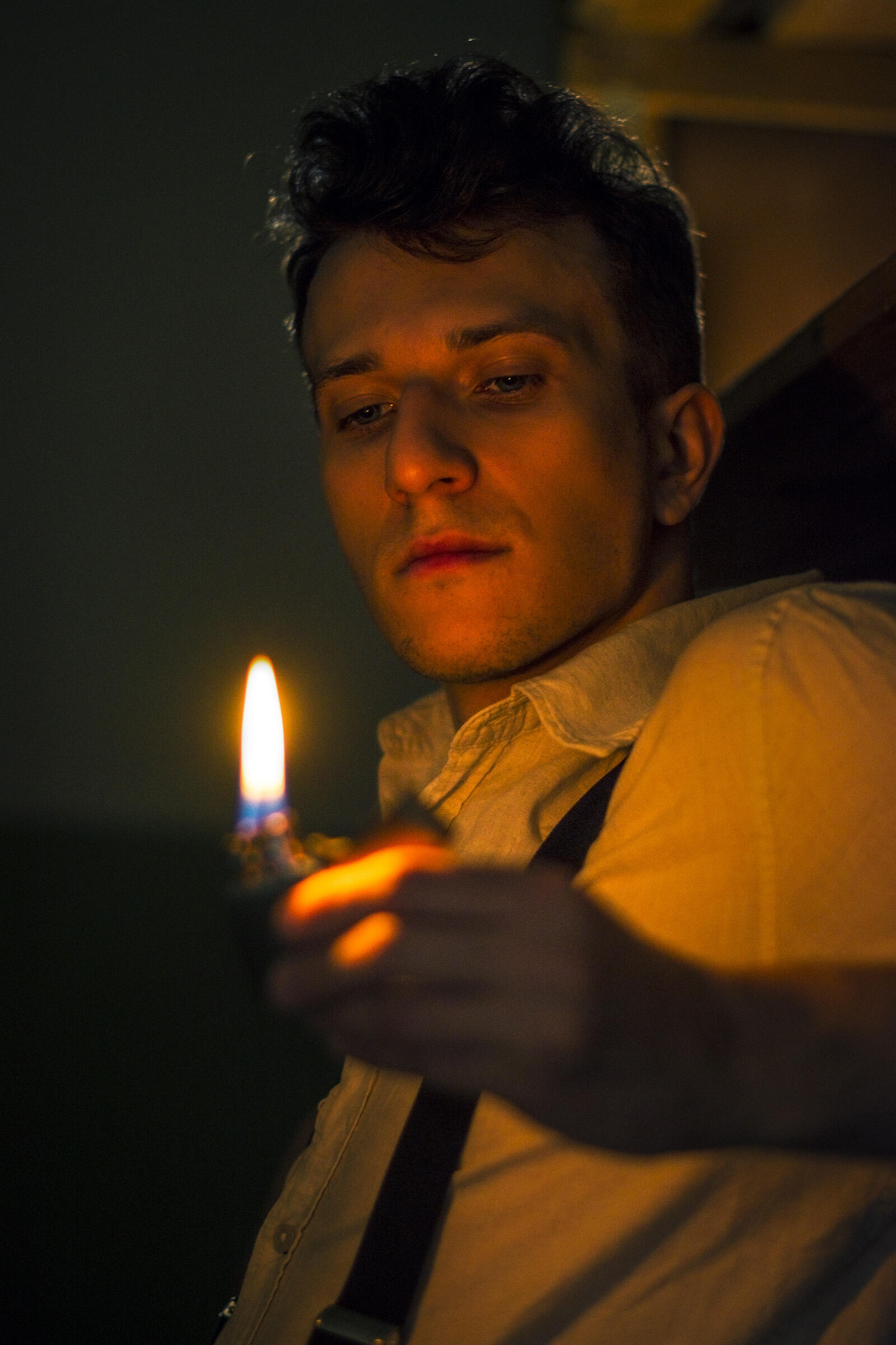 Vaikino asmeninė fotosesija. Portretas, vaikinas žiūri į liepsną