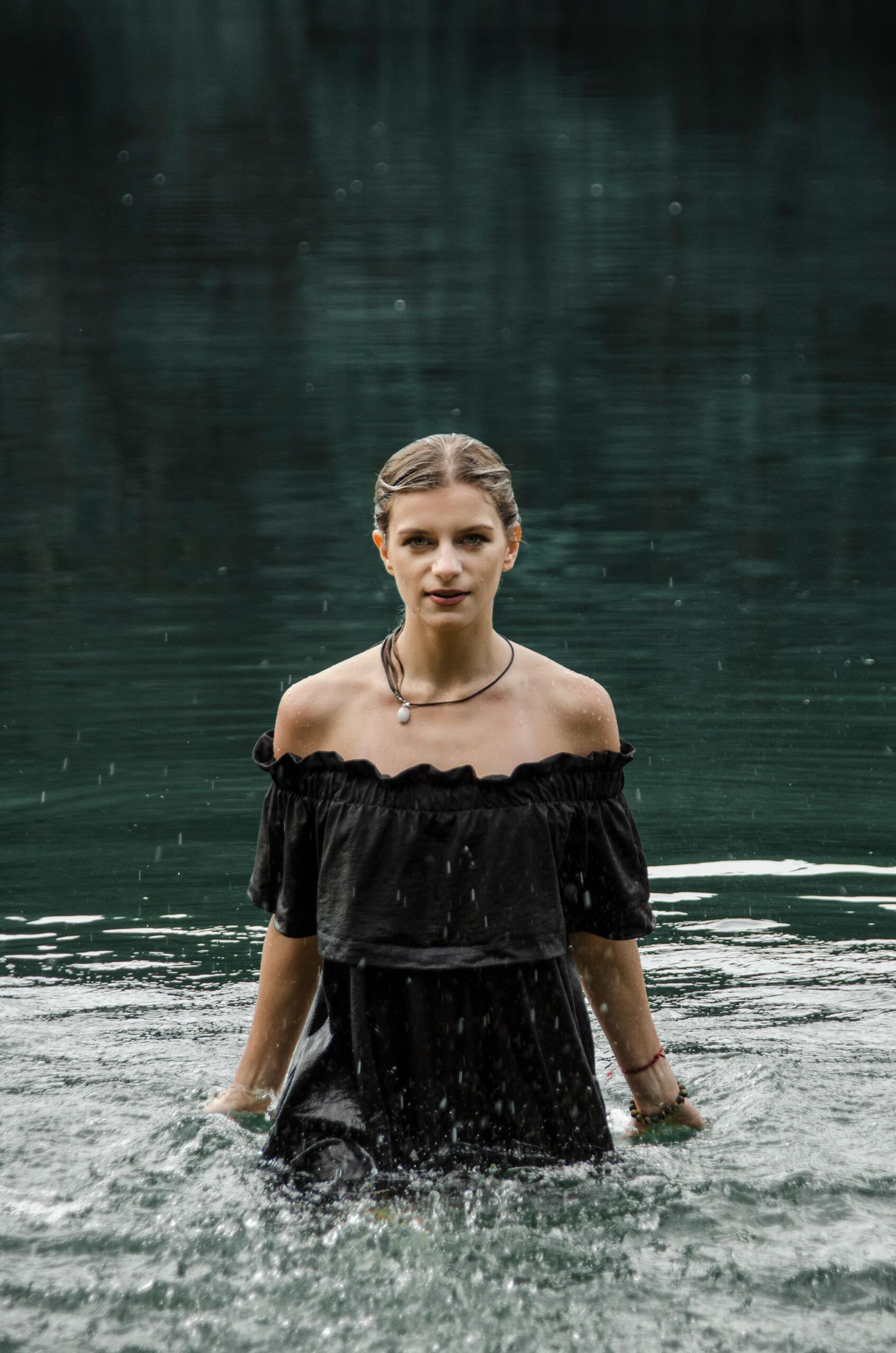 Mergina pozuoja vandenyje, krenta vandens lašai